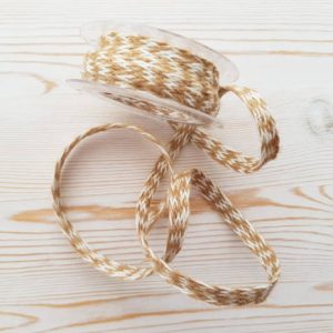Jute linen braid on a light background with a wooden texture.